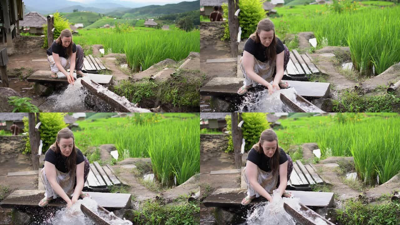 女人在稻田里用手洗手和洗脸