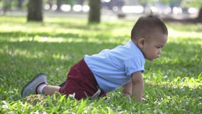 小男孩在公园里爬行和玩球，慢动作
