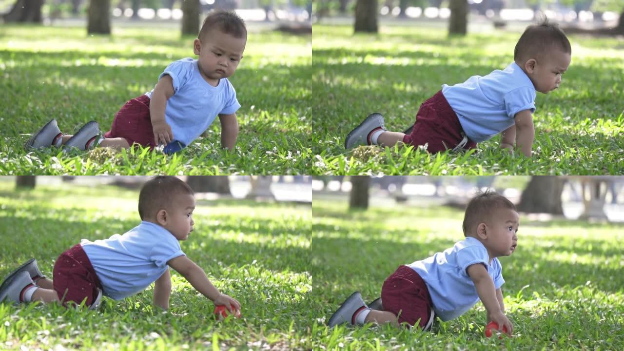 小男孩在公园里爬行和玩球，慢动作
