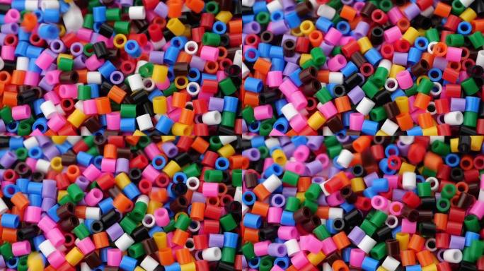 许多彩色易熔塑料珠。特写。