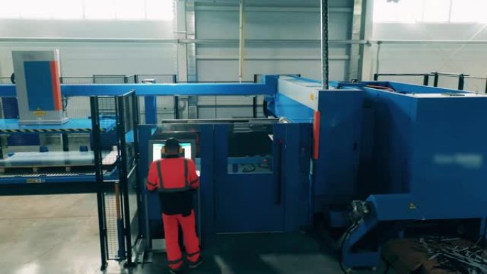 大型切割机由工厂工人管理。工厂内部。