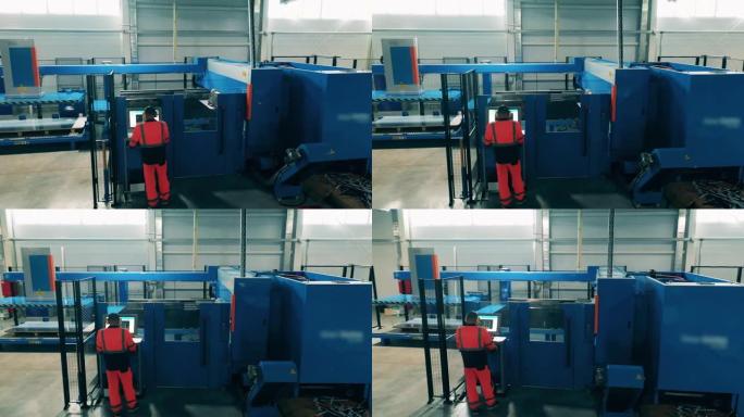 大型切割机由工厂工人管理。工厂内部。