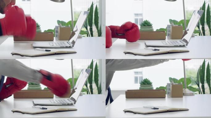4k录像，一个面目全非的商人独自坐在办公室里，用拳击手套打他的笔记本电脑