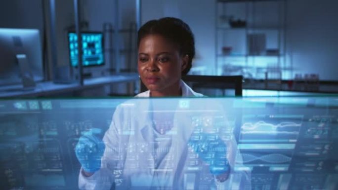 美丽的非裔美国女科学家，穿着实验室外套，戴着防护手套，在现代实验室的HUD上工作。具有深蓝色配色方案