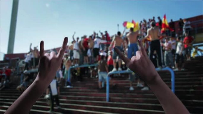 在足球场上，女性手举着魔鬼角手势。