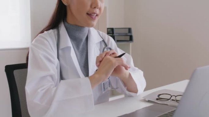 友好的亚洲女医生视频电话在线交谈的电脑笔记本电脑