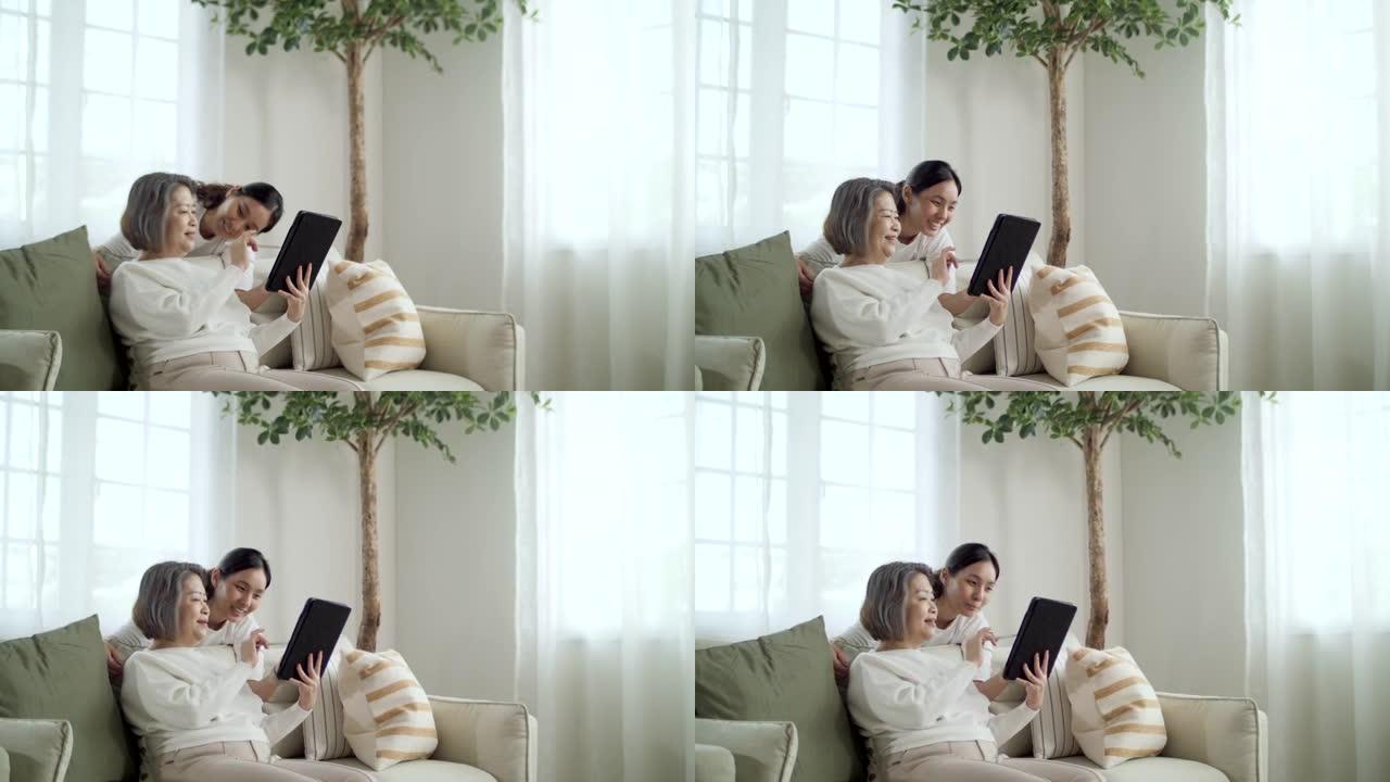 年轻女子和她的母亲在家里一起使用数字平板电脑