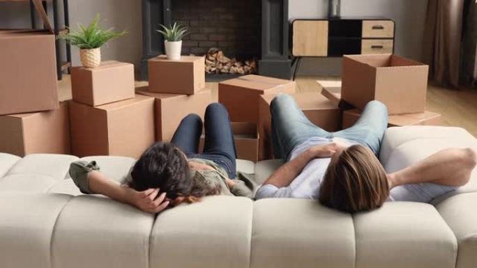 夫妇在靠近一堆包装盒的沙发上放松