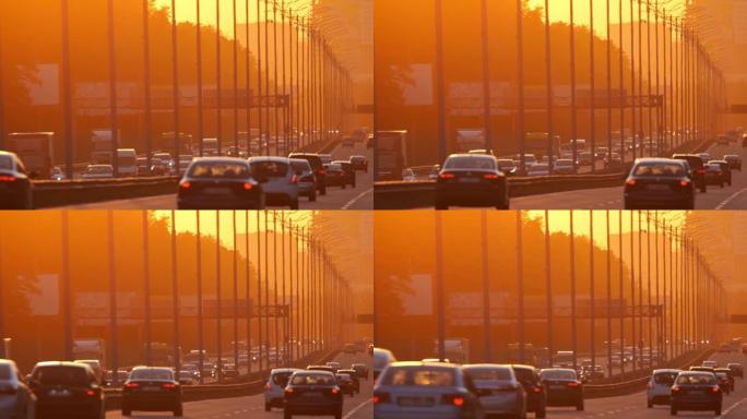 日落时，汽车沿着大城市的高速公路行驶。日落时的城市交通。汽车高峰时间城市街道