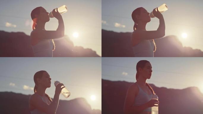 4k视频片段，一名年轻女子在日落时分在乡下跑步后喝水