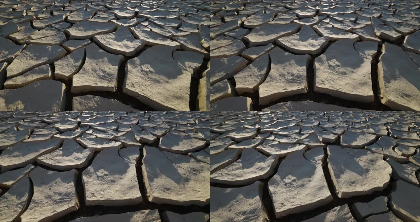 气候变化。由于气候变化和全球变暖造成的干旱，干旱大坝的图案开裂的泥浆表面的圆形特写视图