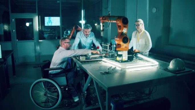 坐在轮椅上的机器人工程师和他的同事的实验室