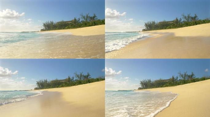 低角度: 海浪席卷巴巴多斯的沙滩的田园诗般的镜头
