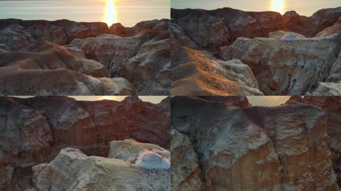海边神奇的雅丹景观在日落的光芒下呈金色和红色