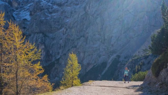 注重身体的女人保持健康的生活方式，在山间小径上徒步旅行，风景令人难以置信