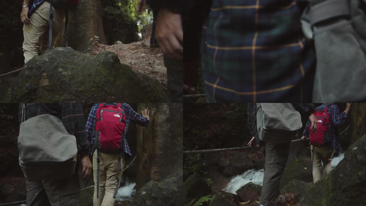 亚洲徒步旅行者爬上森林中的瀑布。