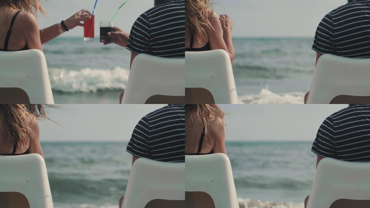 特写后视快乐成功的游客夫妇坐在海边的沙滩椅上触摸酒杯制作吐司