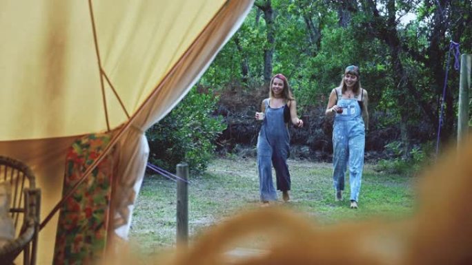 SLO MO两名年轻女子走回自己的帐篷