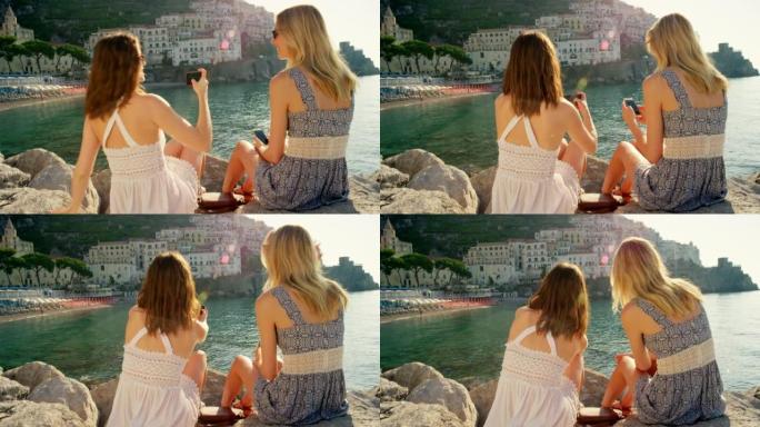 两个朋友坐在海边互相拍照。年轻朋友用手机拍照