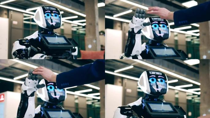 现代机器人正在抚摸穿着西装的人的手