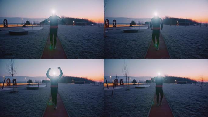 穿着带照明头灯的运动服的男子进行热身运动