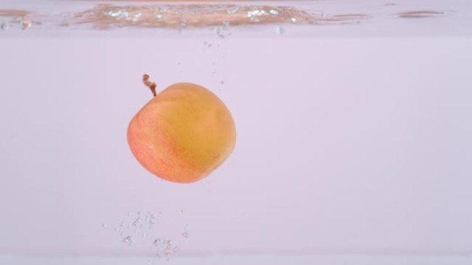 特写: 芬芳的红黄苹果落入晶莹剔透的淡水