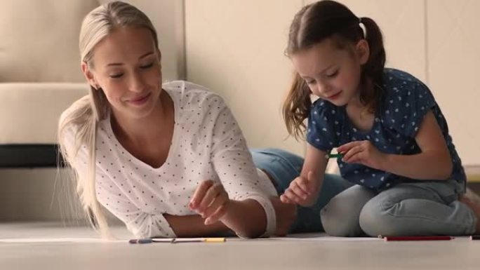 有爱心的妈妈和学龄前的女儿在素描本上用铅笔画画