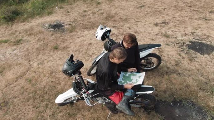 无人机拍摄的男子在摩托车上看着地图
