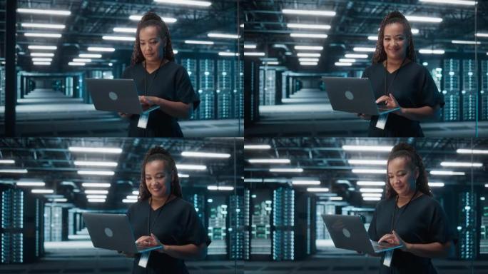 成功的非洲裔美国女性IT专家的肖像使用笔记本电脑，站在数据中心。系统管理员在Web服务上工作。云计算