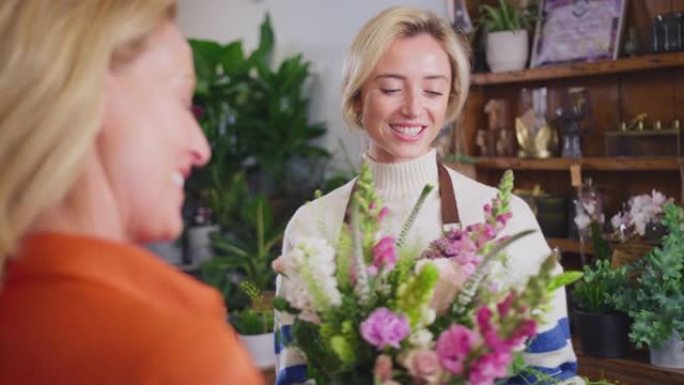 成熟的女人在花店购买一束鲜花-慢动作拍摄