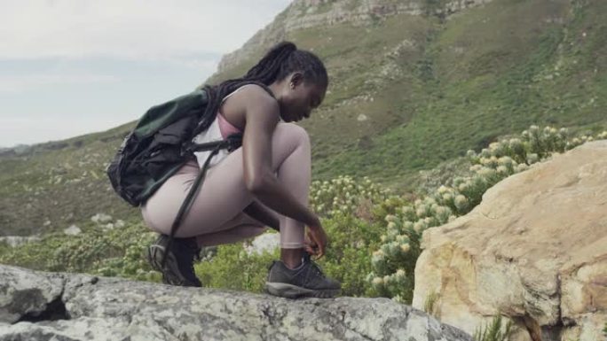 4k视频片段，一名年轻女子在远足时系鞋带