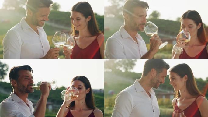 真实的爱情幸福夫妇的镜头是享受浪漫的约会，用白酒杯欢呼，庆祝他们的周年纪念日和风景优美的葡萄园背景下