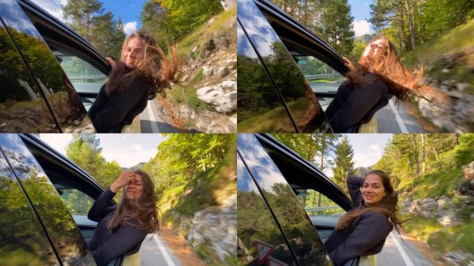 女人享受温暖的秋日，开车穿越森林时从车窗外倾斜