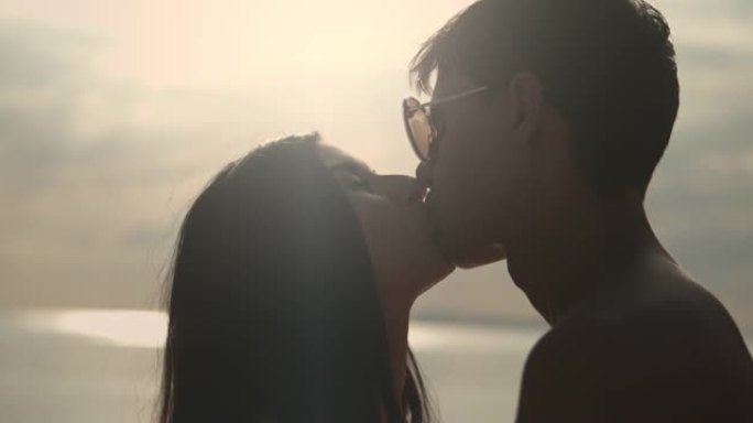 SLO MO夫妇在海滩上互相亲吻