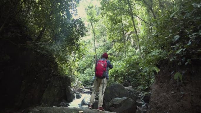 亚洲男性利用假期在森林徒步旅行。