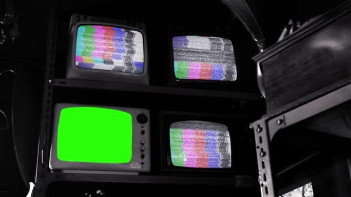 复古电视机打开绿屏，三台复古电视机打开古董店内的测试图案。黑白色调。