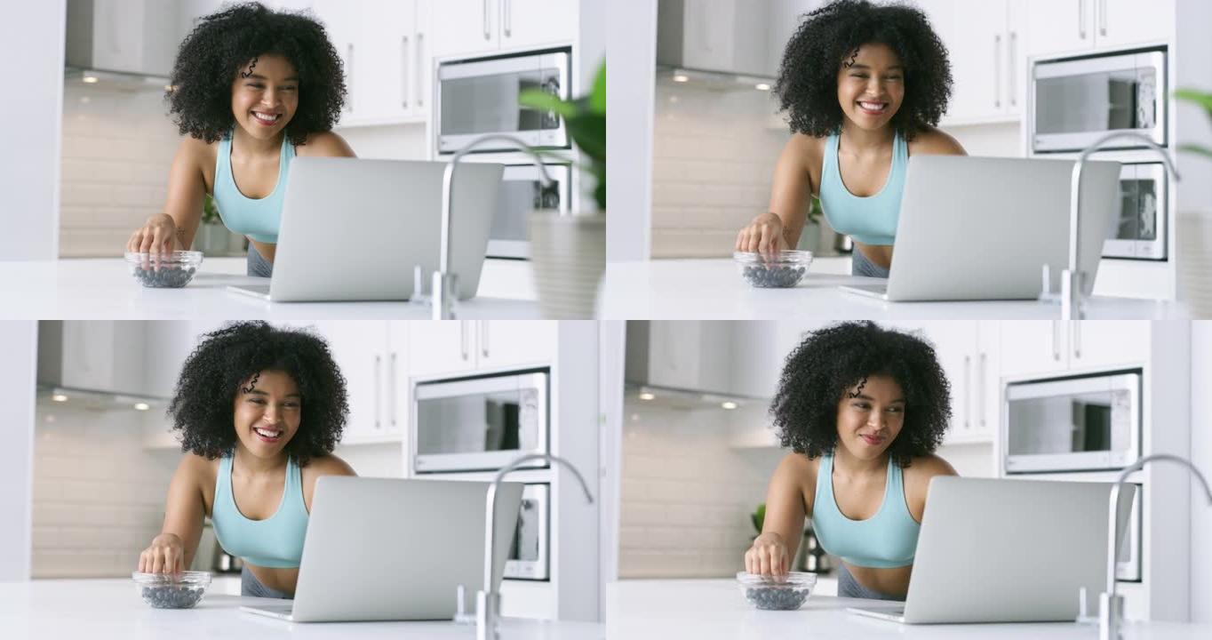4k视频片段，一名年轻女子在家里吃浆果时使用笔记本电脑