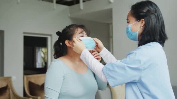 亚洲女护士戴口罩给住院女病人戴口罩