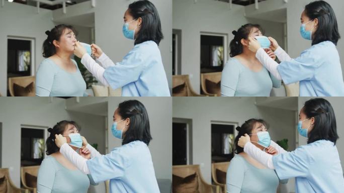 亚洲女护士戴口罩给住院女病人戴口罩
