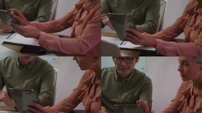 使用平板电脑在会议室讨论的男女商业同事