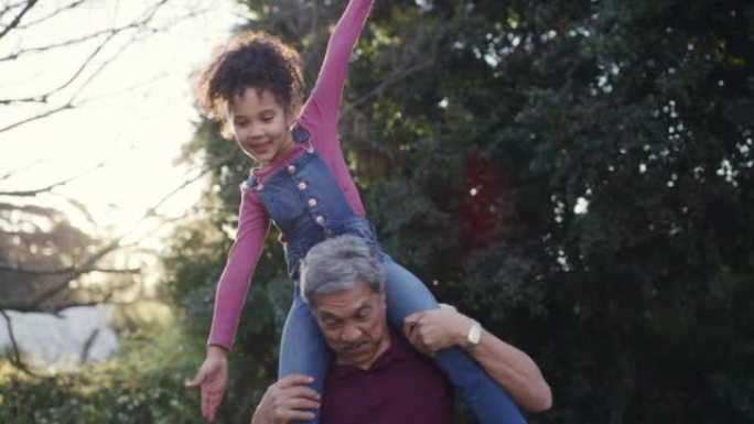 有趣的祖父背着顽皮的孩子，在家庭花园、后院或公园玩耍或玩耍。愚蠢，愚蠢和小女孩与家人建立联系，假装与