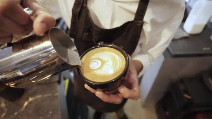 咖啡师在咖啡杯中制作咖啡拿铁艺术