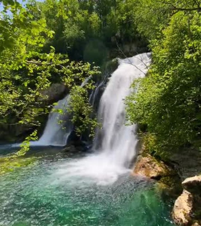 郁郁葱葱的绿色环境中令人惊叹的瀑布，垂直视频