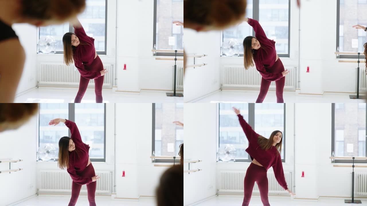 年轻的亚洲妇女在舞蹈课上做伸展运动
