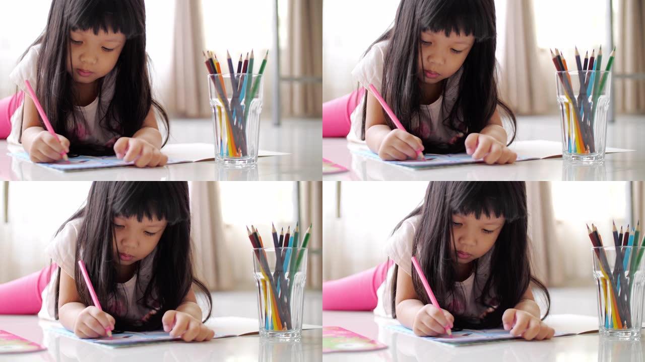 小女孩在家在作业本上画画