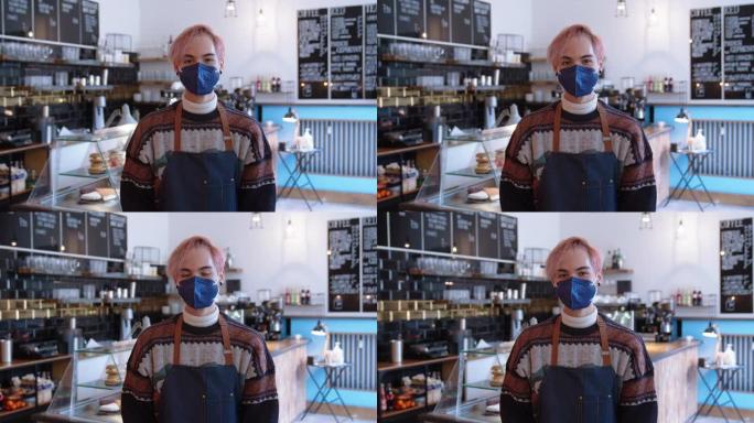在咖啡馆工作的男子的肖像戴着口罩以避免冠状病毒