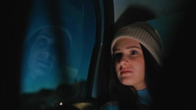 坐在汽车后座上的戴羊毛帽子的年轻女子