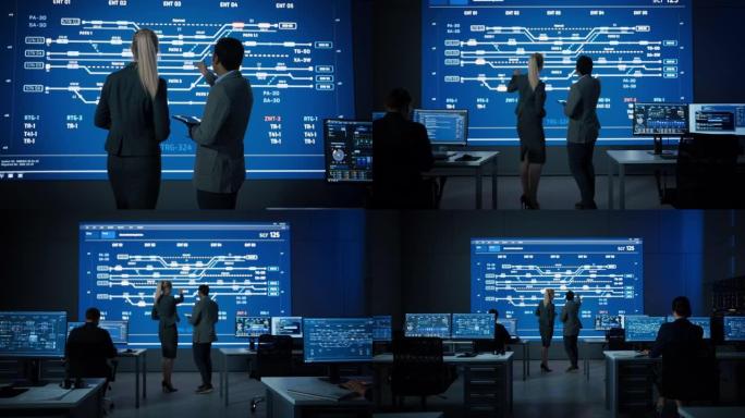 项目经理和计算机科学工程师在使用大屏幕显示基础设施信息图表和数据时交谈。电信公司系统控制监控室。缩小