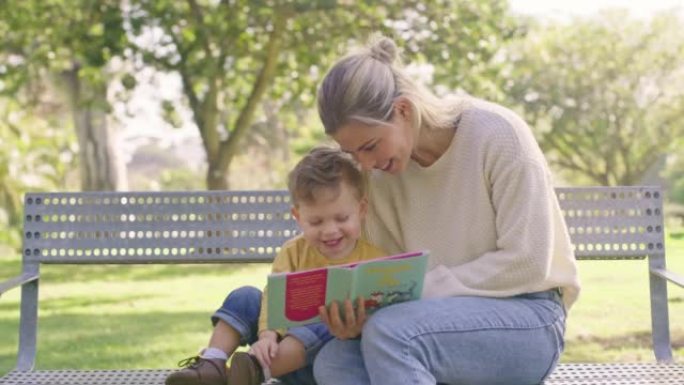 夏天，孩子们和一个女人和她的儿子坐在户外公园的长椅上看书。家庭，爱情和教育与母亲和男孩在外面一起阅读