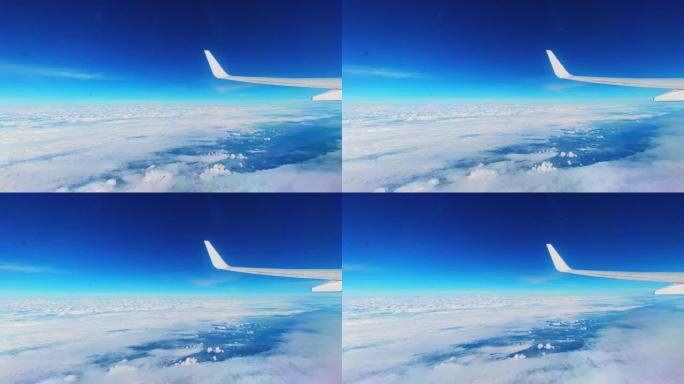 乘飞机旅行。飞机机翼在美丽的云层和蓝天下的景色